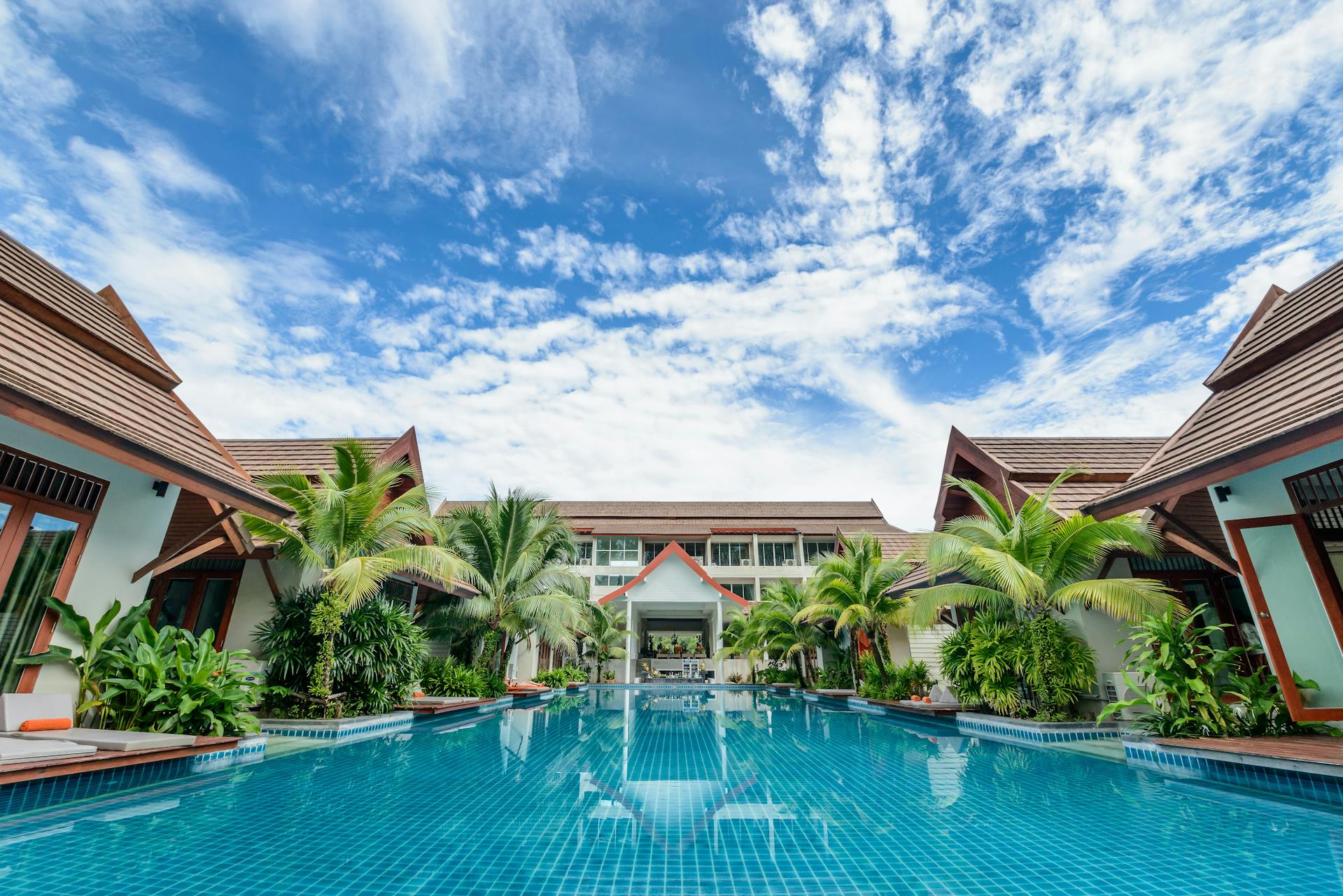 pexels-boonkong-boonpeng-442952-1134176 A large swimming pool with palm trees in the background.